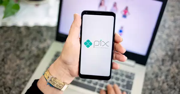 Uma pessoa atenta, com um celular em mãos, explorando o PIX com confiança para transações seguras e convenientes.